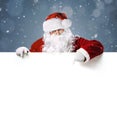 Happy Santa Claus pointing on blank white advertisement banner Royalty Free Stock Photo