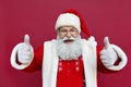 Happy Santa Claus showing thumbs up isolated on red background. Royalty Free Stock Photo