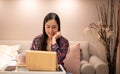 Happy satisfied Asian woman rest at the home office sitting with the laptop after finished work and feels peaceful and relaxed