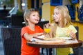 Happy or satisfied boy width girl eating pizza and Royalty Free Stock Photo