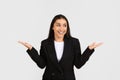 Happy satisfied caucasian businesswoman in suit reacting to great news, raising hands up, rejoicing and smiling Royalty Free Stock Photo