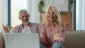 Happy satisfied Caucasian married couple grandfather grandmother man woman talking on video call using laptop at home