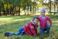Happy and satisfied children play together in autumn park Royalty Free Stock Photo