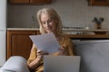 Happy satisfied mature landlady woman reading paper mail letter