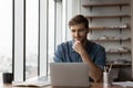 Happy satisfied millennial man using laptop at office workplace