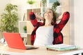 Happy satisfied student relaxing sitting on a desk at home