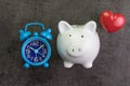 Happy savings concept with white piggy bank, retro alarm clock a Royalty Free Stock Photo