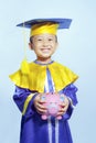 Happy scholar dressed toddler with piggybank Royalty Free Stock Photo