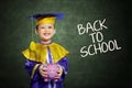 Happy scholar dressed toddler with piggybank Royalty Free Stock Photo