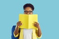 Happy school, college or university student girl in glasses hiding half of her face behind book Royalty Free Stock Photo