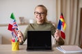 Happy school girl with flags showing empty laptop screen Royalty Free Stock Photo