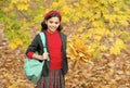 happy school girl handful of yellow maple leaves in park, school time