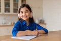 Happy School Girl Learning, Writing in Notebook Wearing Earphones Indoor Royalty Free Stock Photo