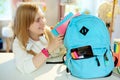 Happy school girl packing for school at home in sunny day Royalty Free Stock Photo