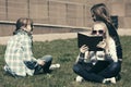 Happy school girls sitting on grass in campus Royalty Free Stock Photo