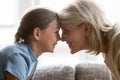 Happy school granddaughter and mature older grandmother touching foreheads. Royalty Free Stock Photo