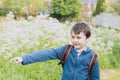 Happy school kid with backpack having fun while walk to school in the morning,Outdoor portrait young boy pointing finger out with Royalty Free Stock Photo