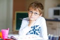 Happy school kid boy with glasses at home making homework Royalty Free Stock Photo