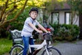 Happy school kid boy having fun with riding of bicycle. Active child with safety helmet making sports with bike in Royalty Free Stock Photo