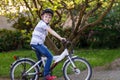 Happy school kid boy having fun with riding of bicycle. Active child with safety helmet making sports with bike in Royalty Free Stock Photo