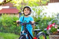 Happy school kid boy having fun with riding of bicycle. Active healthy child with safety helmet making sports with bike Royalty Free Stock Photo