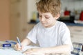 Happy school kid boy at home making homework Royalty Free Stock Photo