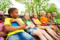 Happy school kids on bench sit in row together Royalty Free Stock Photo
