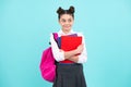 Happy school teenage girl with book and copybook. Teenager schoolgirl student, blue background. Learning and