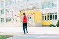 Happy schoolboy boy, in glasses with a backpack, runs to school with pleasure, schoolboy boy on the background of the school Royalty Free Stock Photo