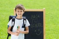 Happy schoolboy with pens and backpack against the blackboard. Education, back to school concept Royalty Free Stock Photo