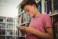 Happy schoolboy using digital tablet in library Royalty Free Stock Photo