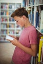 Happy schoolboy using digital tablet in library Royalty Free Stock Photo