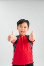 Happy schoolboy wearing backpack and giving thumbs up isolated on white Royalty Free Stock Photo