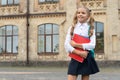 Happy schoolchild in uniform back-to-school carrying books and backpack, copy space