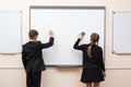 Happy schoolchild writing on blackboard. Royalty Free Stock Photo