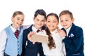 Happy schoolchildren pretending to be businesspeople taking selfie on smartphone Isolated On White.