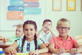 Happy schoolchildren studing in classroom during lesson at primary international school