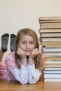 Happy schoolgirl with books in the room. vertical photo