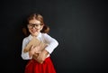 Happy schoolgirl preschool girl with book near school blackboard Royalty Free Stock Photo