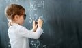 Happy schoolgirl preschool girl with book near school blackboard Royalty Free Stock Photo