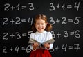 Happy schoolgirl preschool girl with book near school blackboard Royalty Free Stock Photo