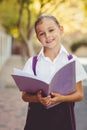 Happy schoolgirl reading book in campus Royalty Free Stock Photo