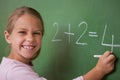 Happy schoolgirl writing a number Royalty Free Stock Photo