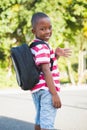 Happy schoolkid waving hand in campus