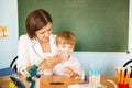 Happy schoolteacher helping a schoolboy doing an addition on a blackboard. Back to school concept. Royalty Free Stock Photo