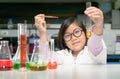 Happy scientist girl making experiment with test tube