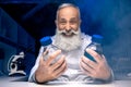 Happy scientist looking at bottles with reagents in hands in laboratory Royalty Free Stock Photo