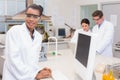 Happy scientist smiling at camera while colleagues working together Royalty Free Stock Photo