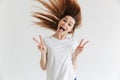 Happy screaming woman in t-shirt showing peace gestures