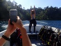 A happy scuba diver pose from back with a full of equipment on boat before commencing of diving